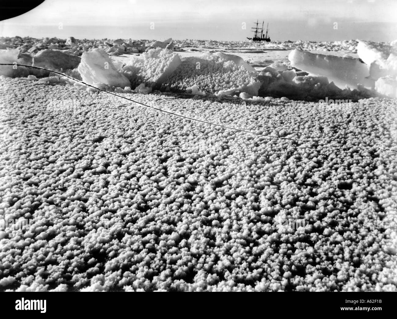 Crystal ice flowers on the surface of the newly frozen ice with Endurance frozen behind Imperial