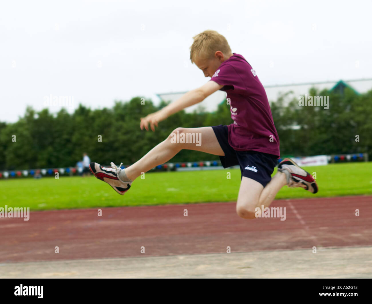boy competing in long jump event on a sports day Stock Photo