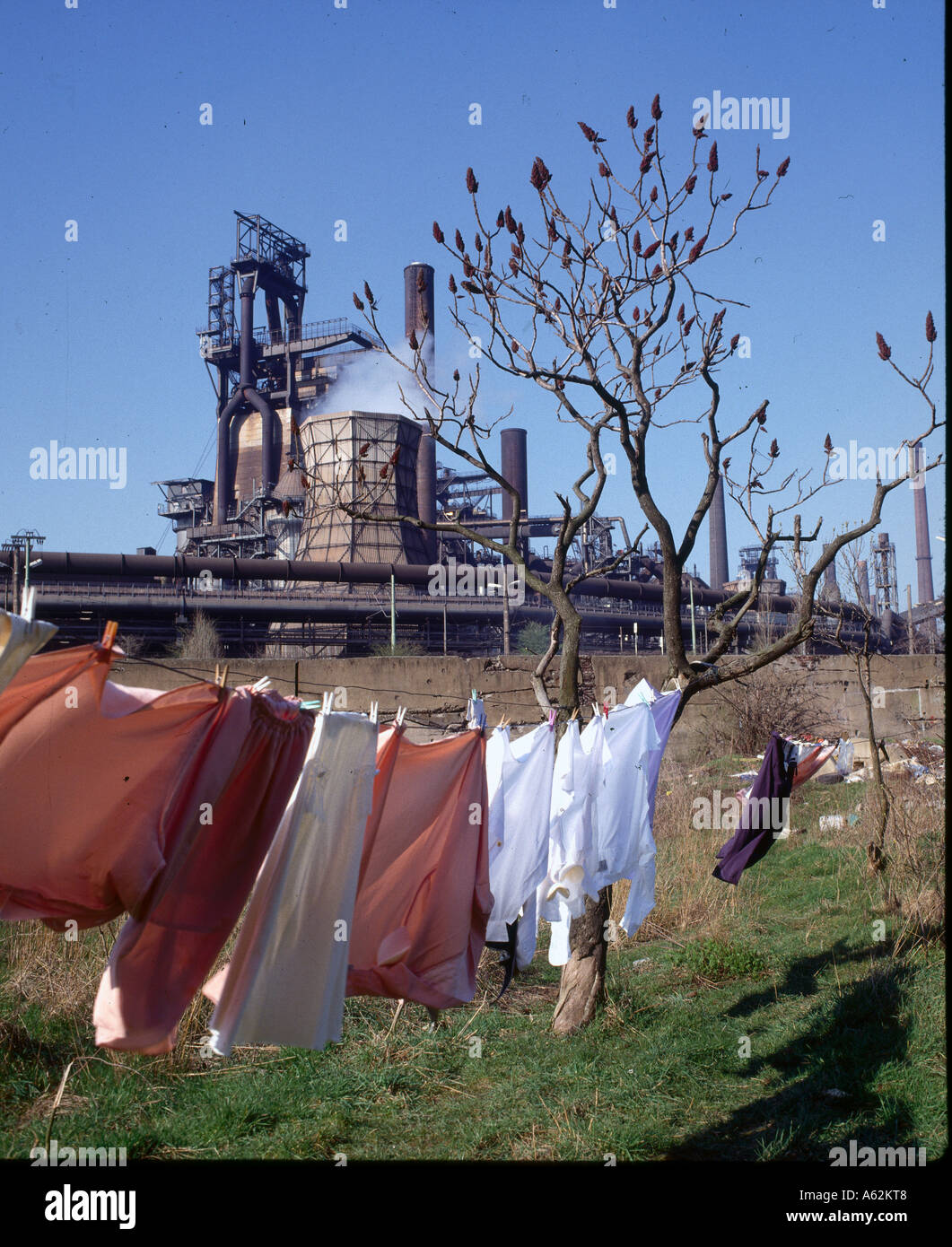 Clothes drying on clothesline with smelting plant in background
