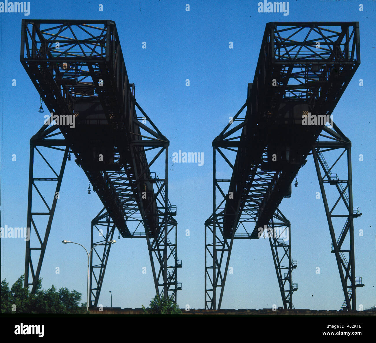 Low angle view of rusty cranes against blue sky, Germany Stock Photo ...
