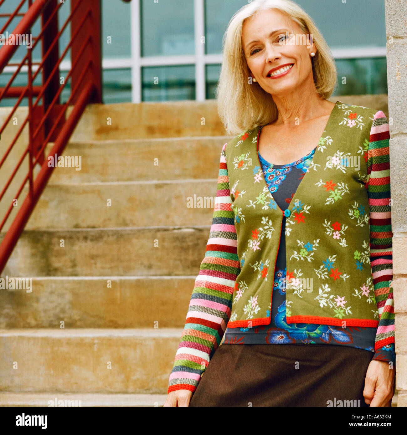 Portrait of a mature woman standing on a staircase and smiling Stock ...