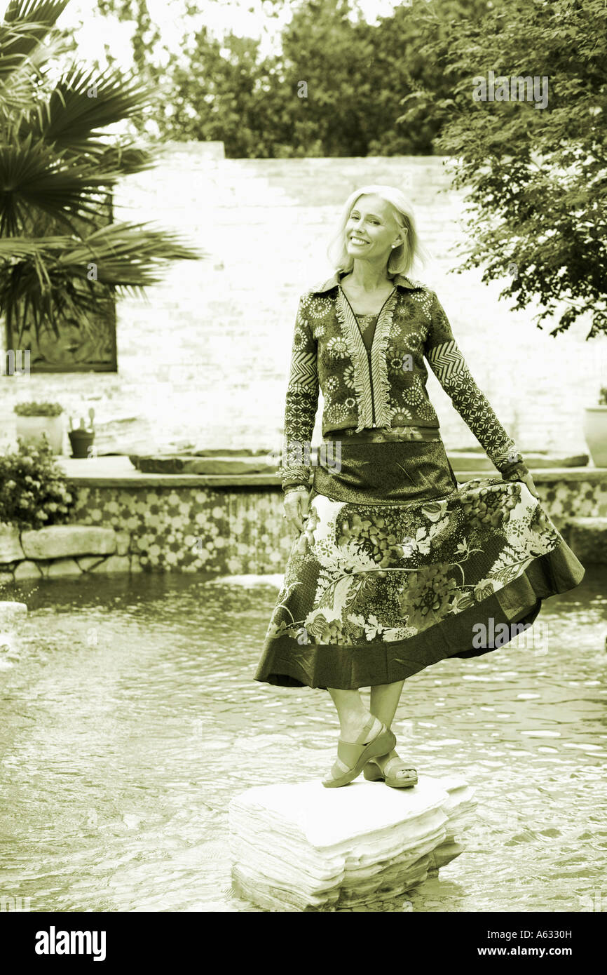 Portrait of a mature woman standing on a rock and smiling Stock Photo ...