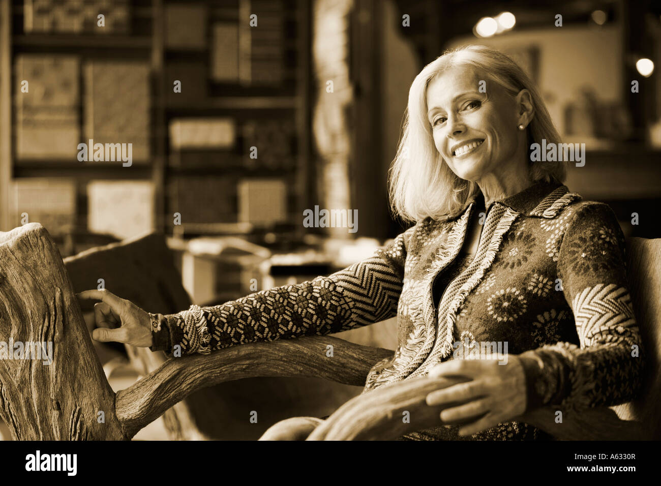 Portrait of a mature woman sitting on a chair and smiling Stock Photo ...