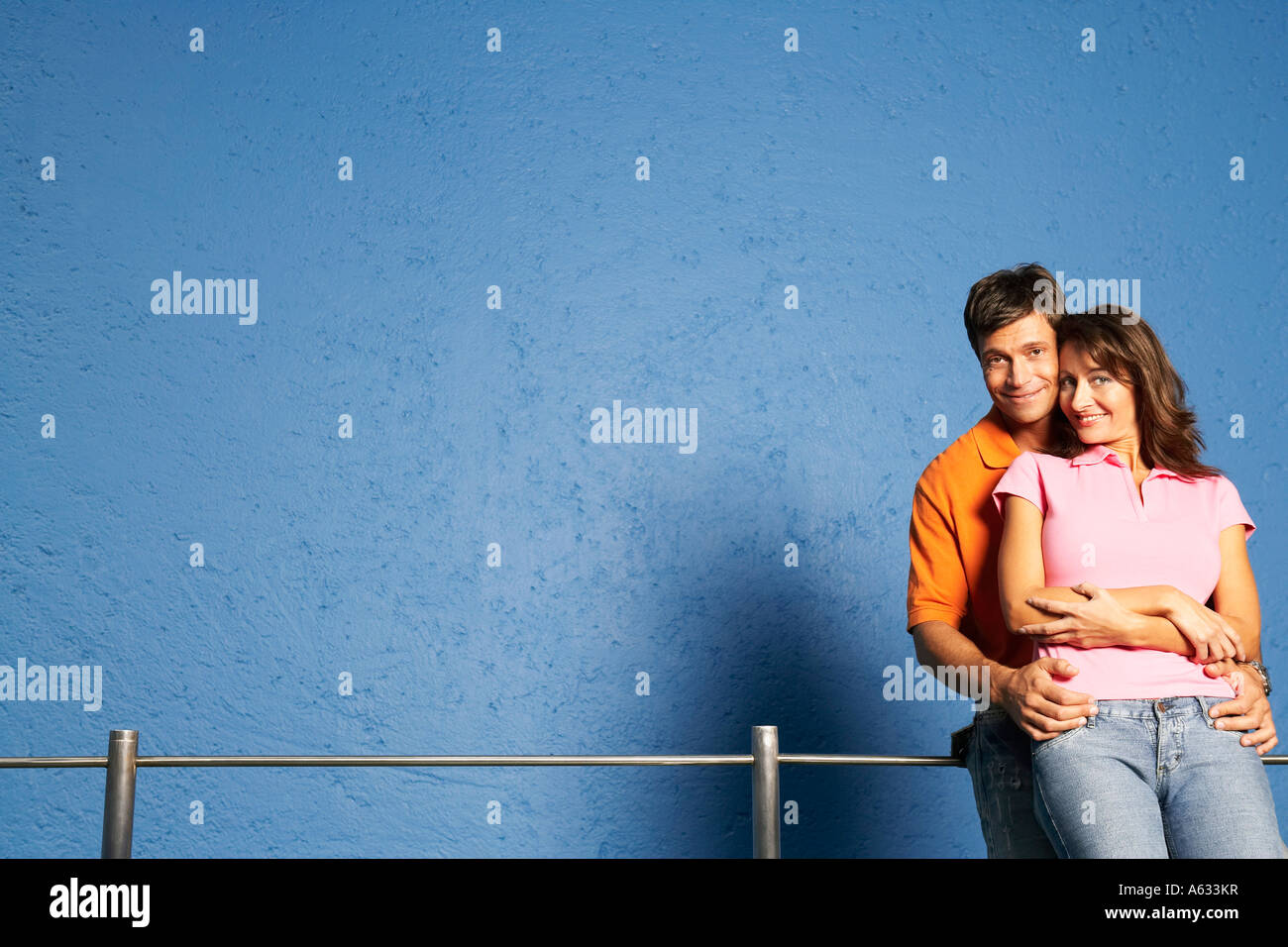 Portrait of a mid adult man embracing a mid adult woman from behind ...
