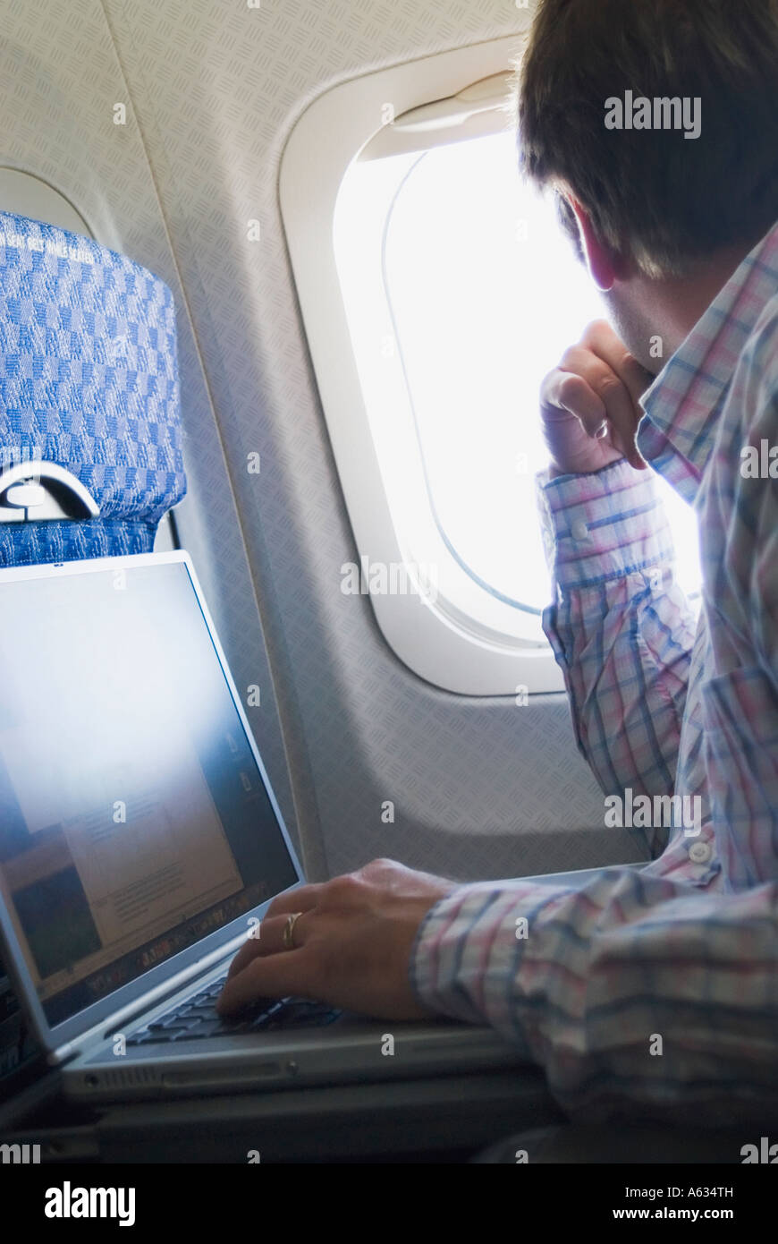 Man with laptop on airplane Stock Photo - Alamy