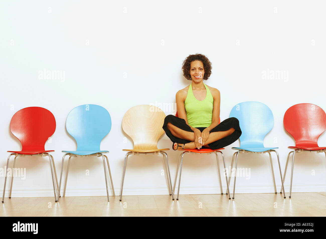 Portrait of a mature woman sitting on a chair and smiling Stock Photo ...