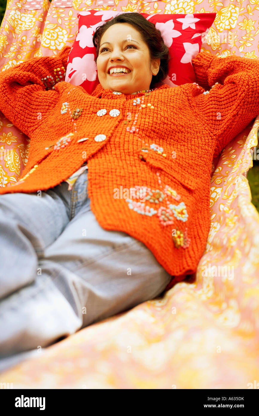 Mid adult woman lying in a hammock and smiling Stock Photo - Alamy