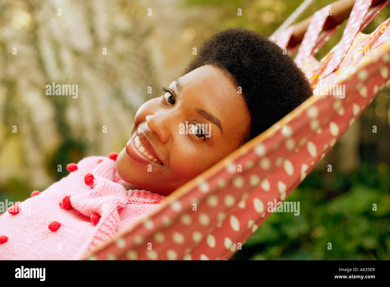 Portrait of a young woman smiling and lying in a hammock Stock Photo ...