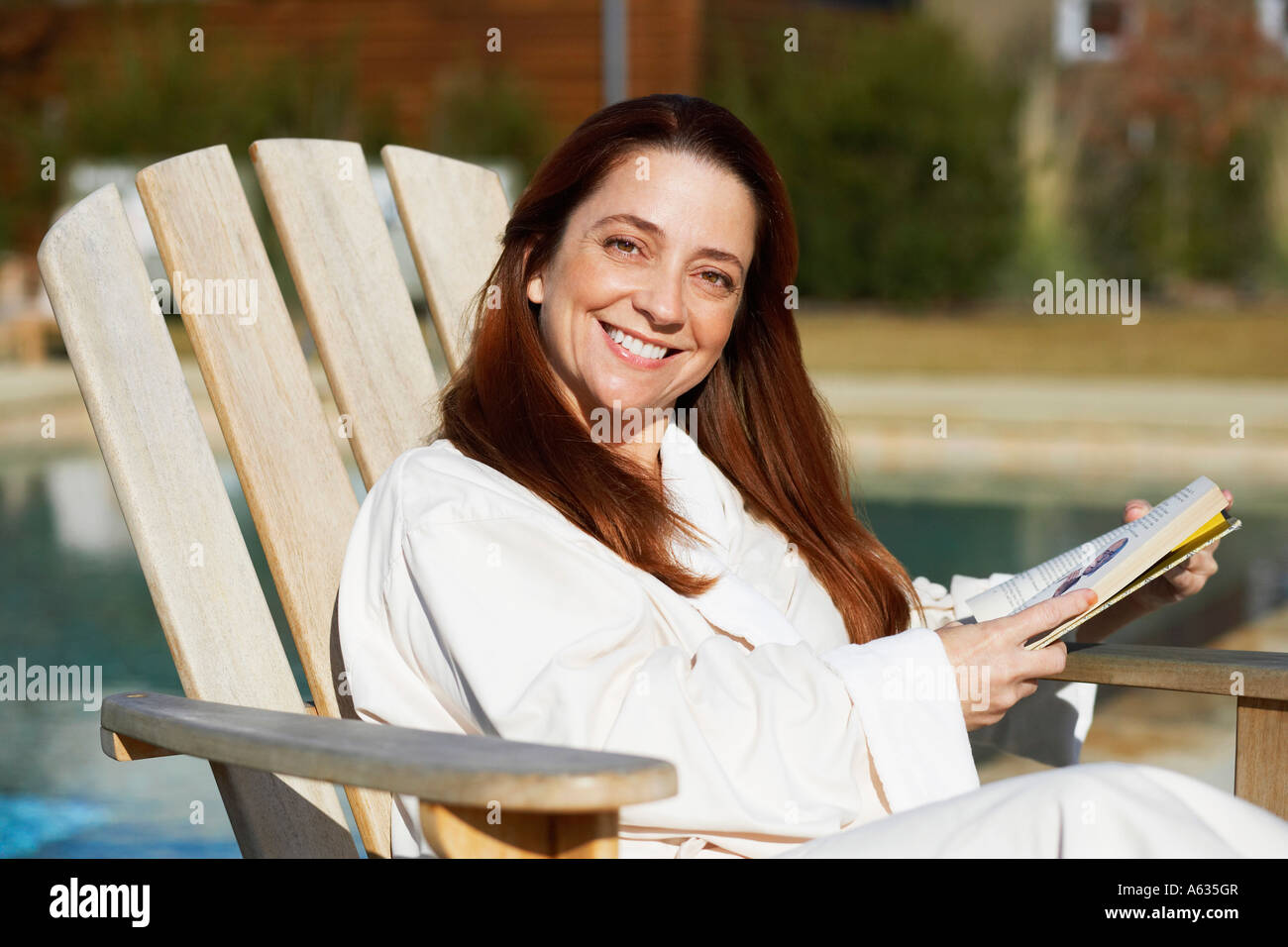 Portrait of a mature woman sitting on a lounge chair and smiling Stock ...