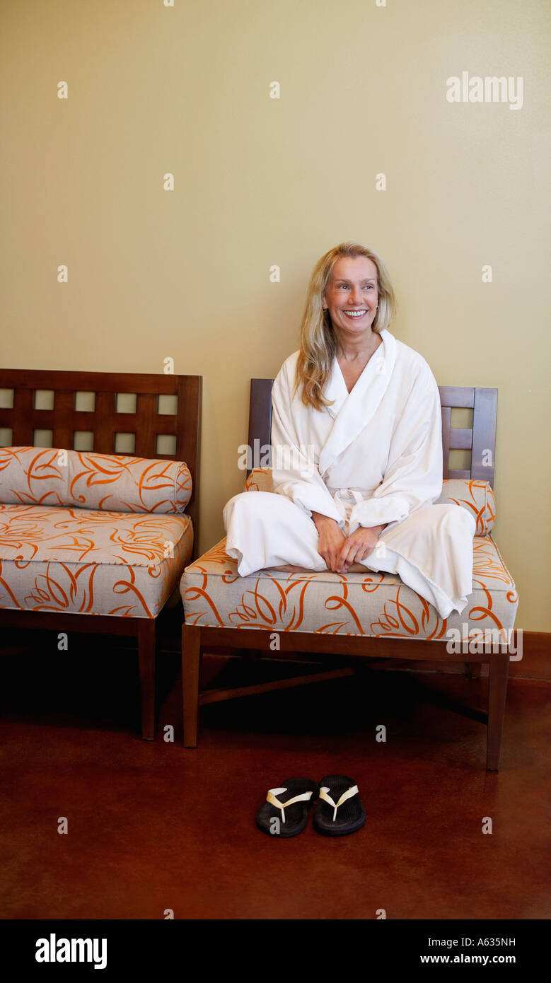 Mature woman sitting on a chair and smiling Stock Photo - Alamy