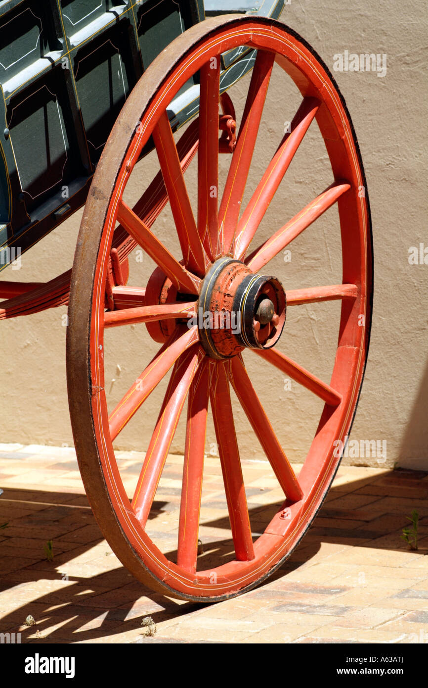 A red cartwheel with wooden spokes and an iron rim Stock Photo