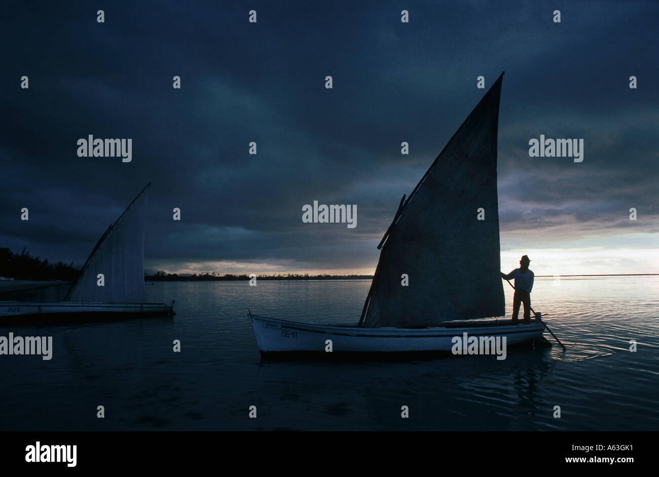 Silhouette of a person sailing on a sailboat Mauritius Stock Photo
