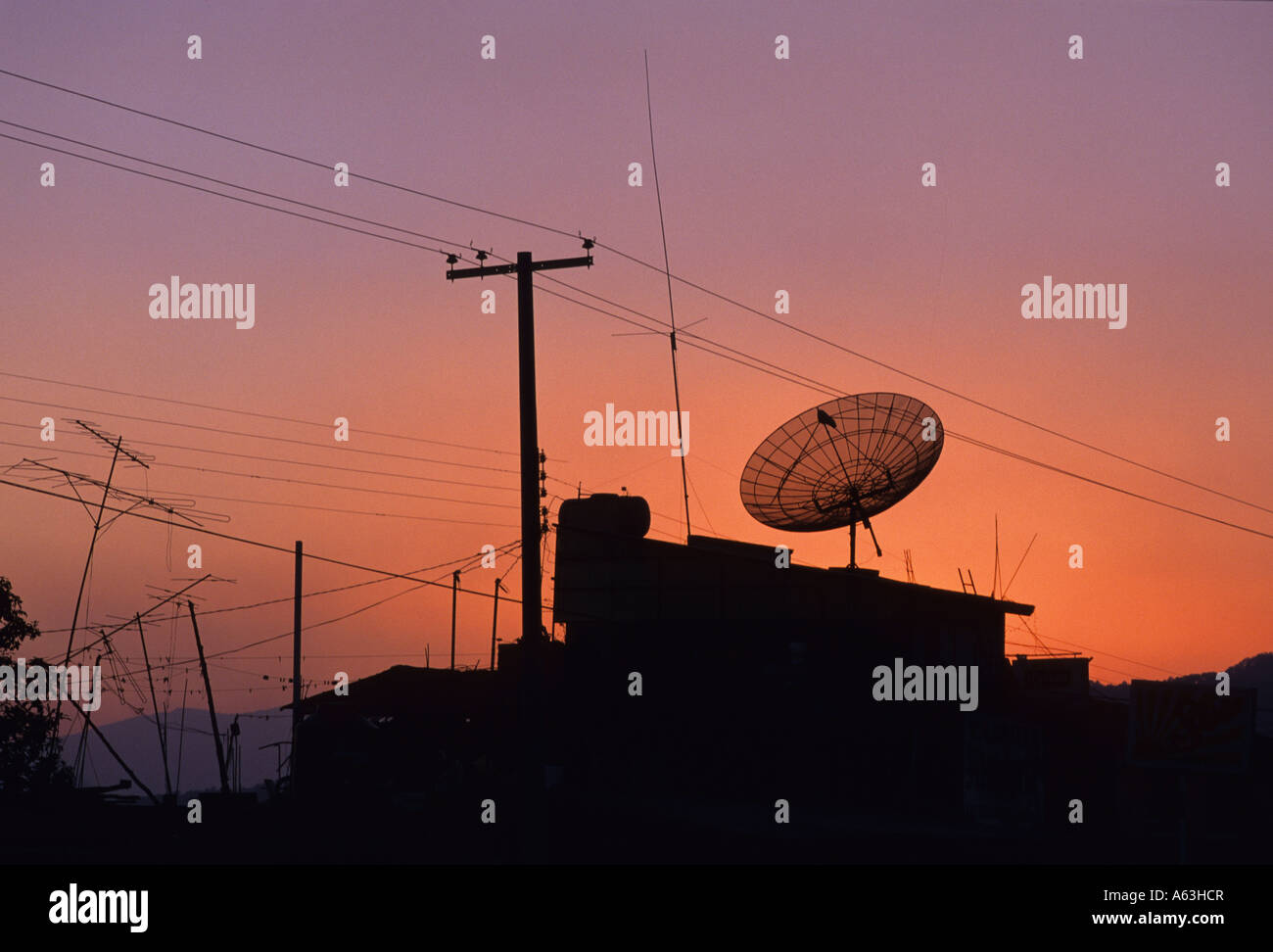 TV satellite dish, TV aerials, telephone wires and telegraph pole at