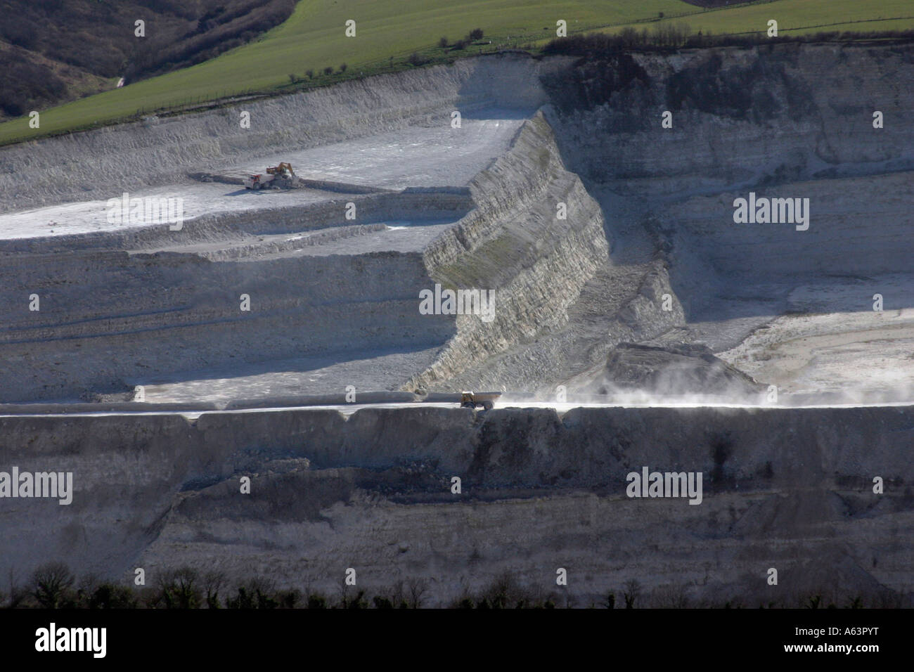 aerial shot of tipper truck driving along lip of chalk quarry supplying local Lafarge cement works at Westbury, Wiltshire, UK Stock Photo