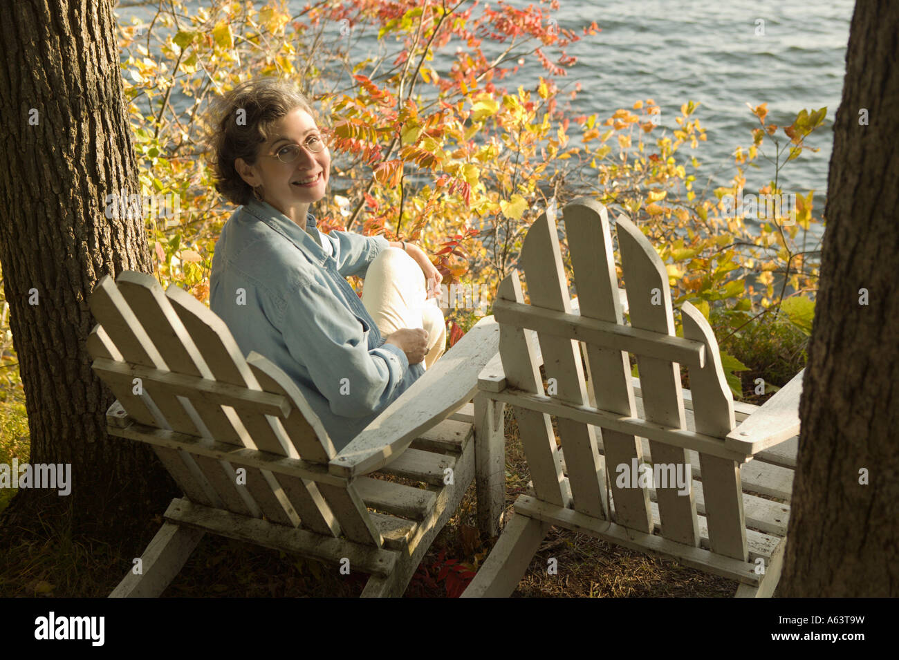 Retired woman relaxing by water Stock Photo