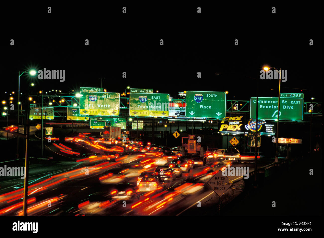 Freeway interchange signs and heavy traffic At Night Dallas Texas Stock