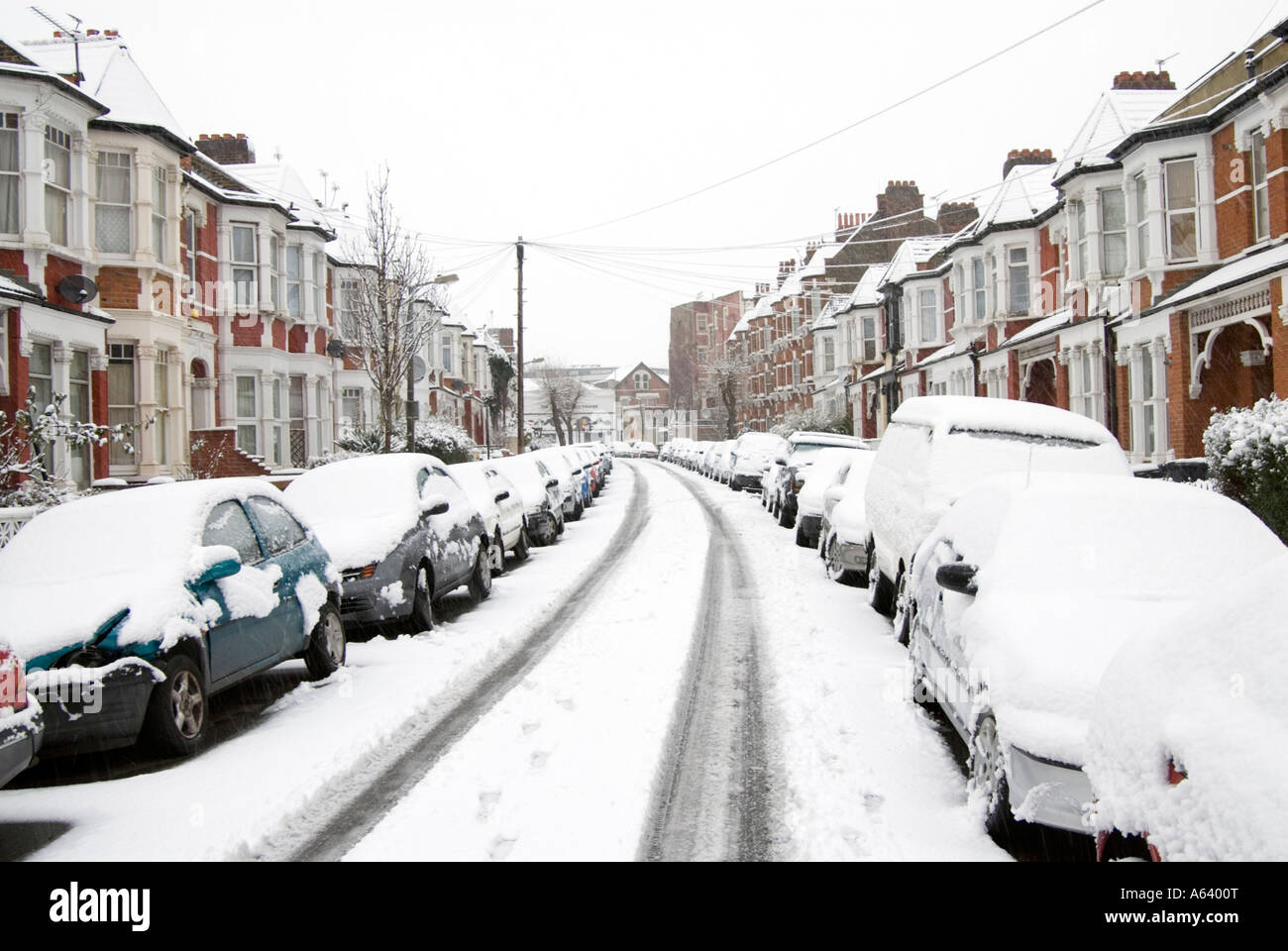 Snow covered cars in residential street London England UK Stock Photo