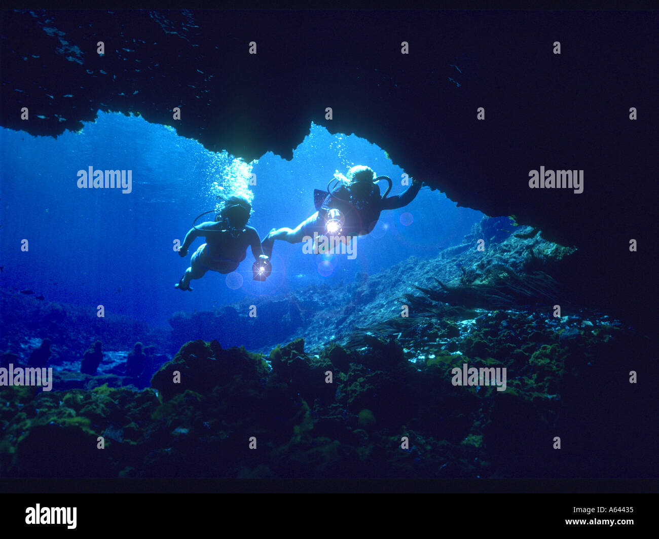 two skin divers exploring underwater cave Stock Photo