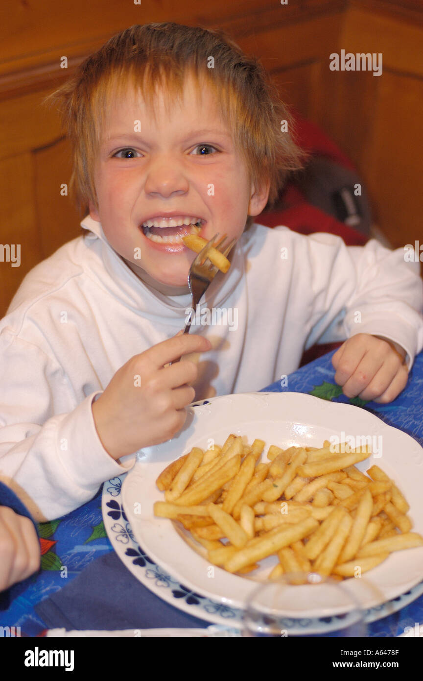 Six years old boy eating pommes frittes Stock Photo Alamy