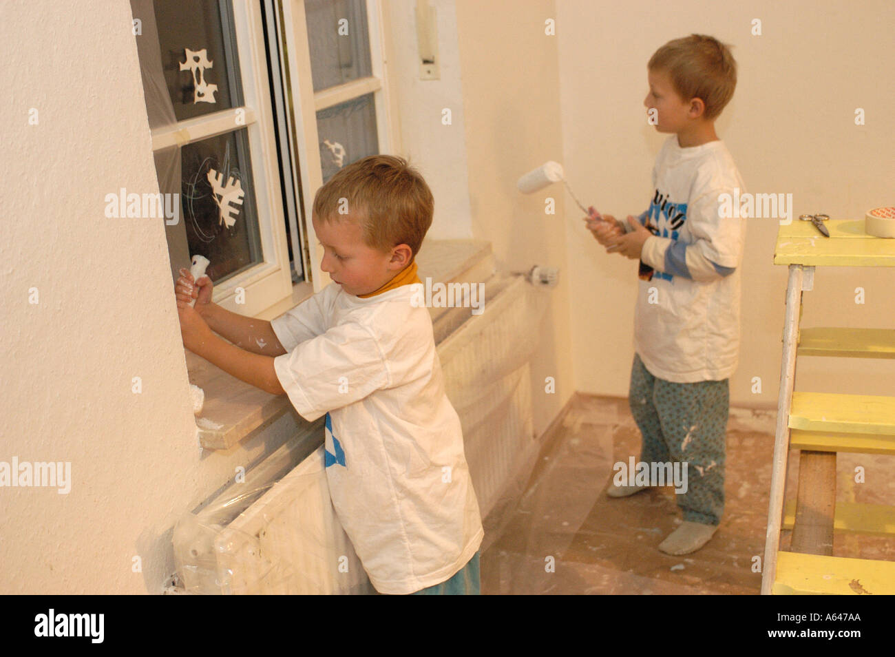 Two little boys painting wall Stock Photo Alamy