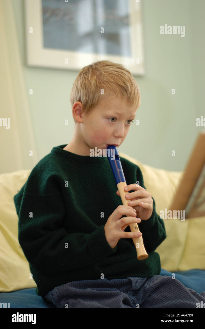 Seven year old boy playing flute Stock Photo Alamy