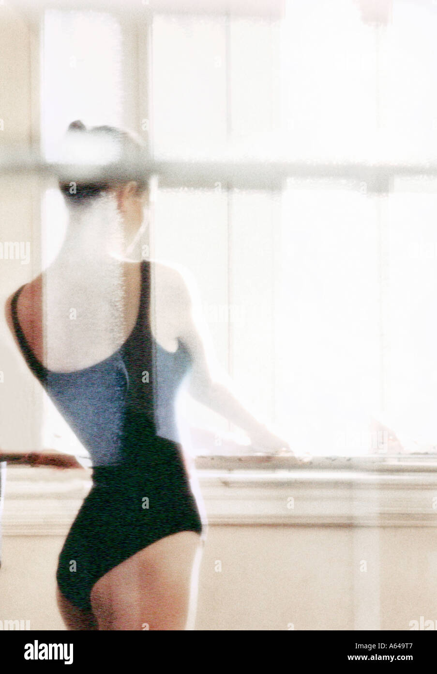 Ballerina at window in dance studio Stock Photo
