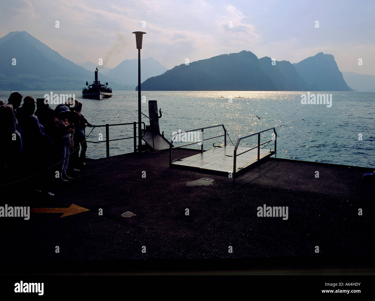 view from jetty of vitznau to historic paddle steamer and mount burgenstock right swiss alpes switzerland Stock Photo