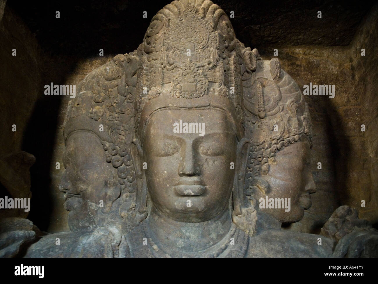 Shiva statue inside the cave temples on Elephanta Island in India showing the  three heads of creator preserver and destroyer Stock Photo