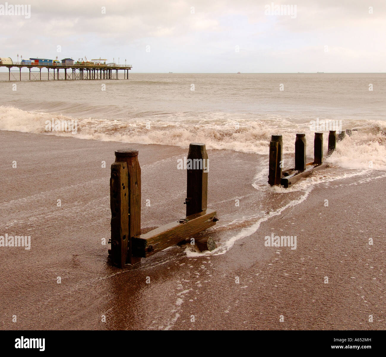 Almost sepia toned image of waves crashing over a groyne on the foreshore at Teignmouth South Devon Stock Photo