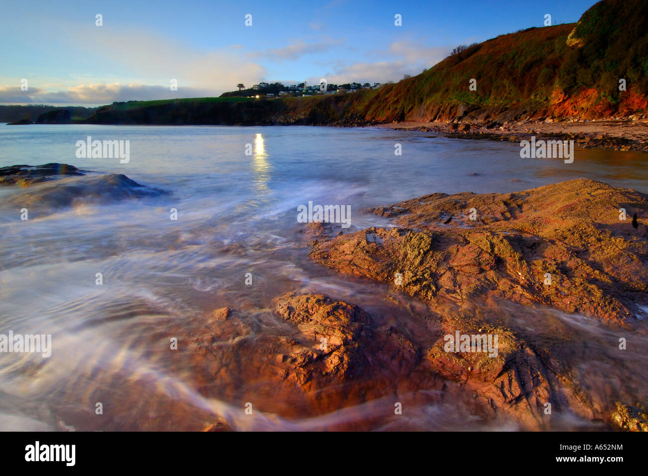 Beautiful dawn light at Saltern Cove near Paignton South Devon with the sea swirling around the exposed rocks Stock Photo