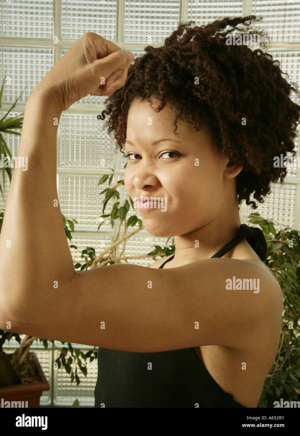 Pretty Black woman flexing her muscles Stock Photo - Alamy