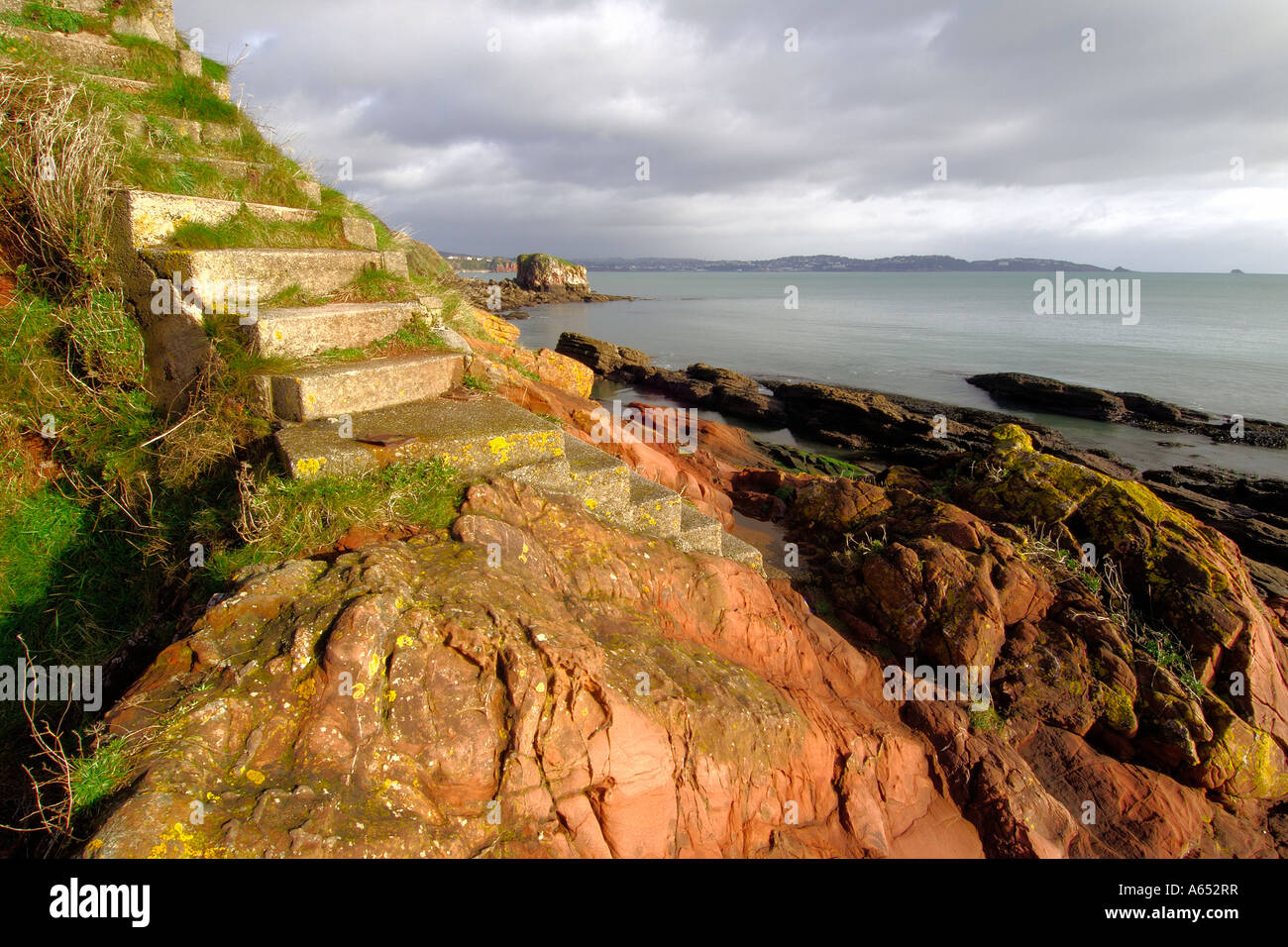 Treacherous stone steps cut into the cliff leading down to Shell Cove near Paignton South Devon Stock Photo