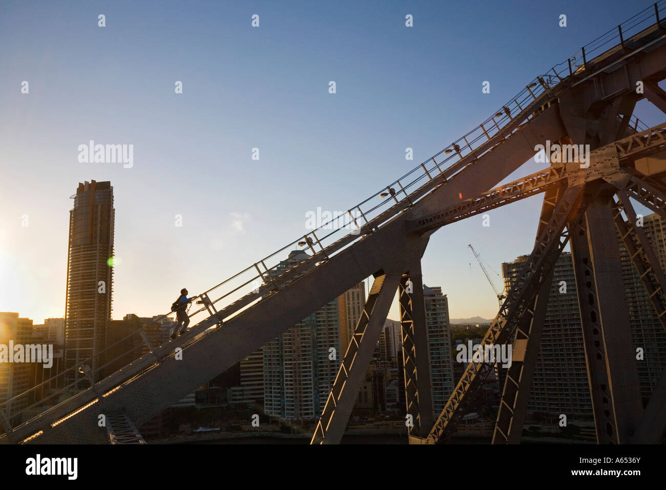 A climber traverses the steel girders of the Story Bridge in Brisbane Stock Photo