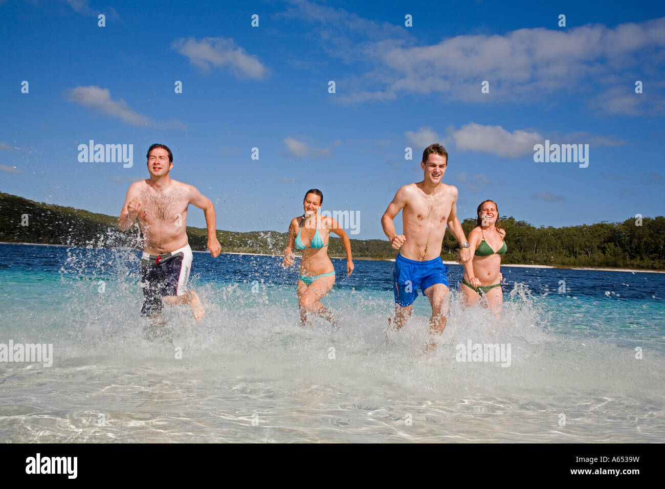 A group have fun in the clear waters of Lake Mckenzie on Fraser Island Ringed by a white sandy beach Stock Photo
