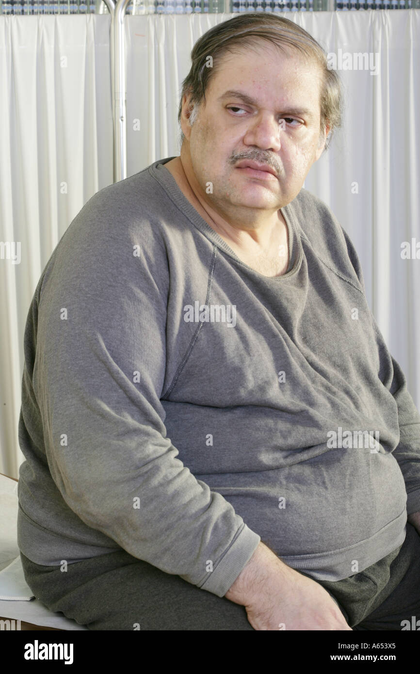 Overweight man waits in doctor's office or medical clinic. Stock Photo