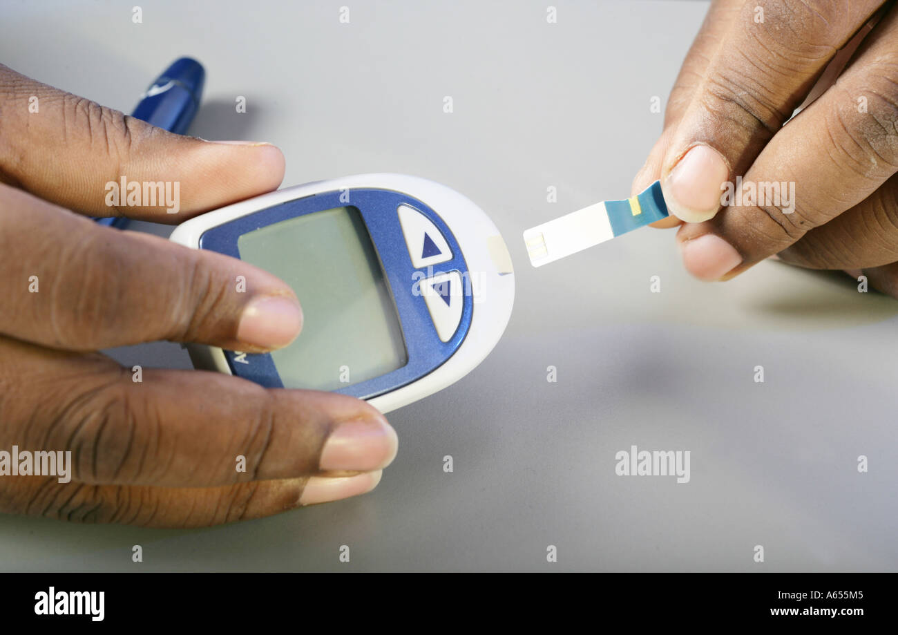 Diabetes testing using a glucose monitor and strip Stock Photo Alamy