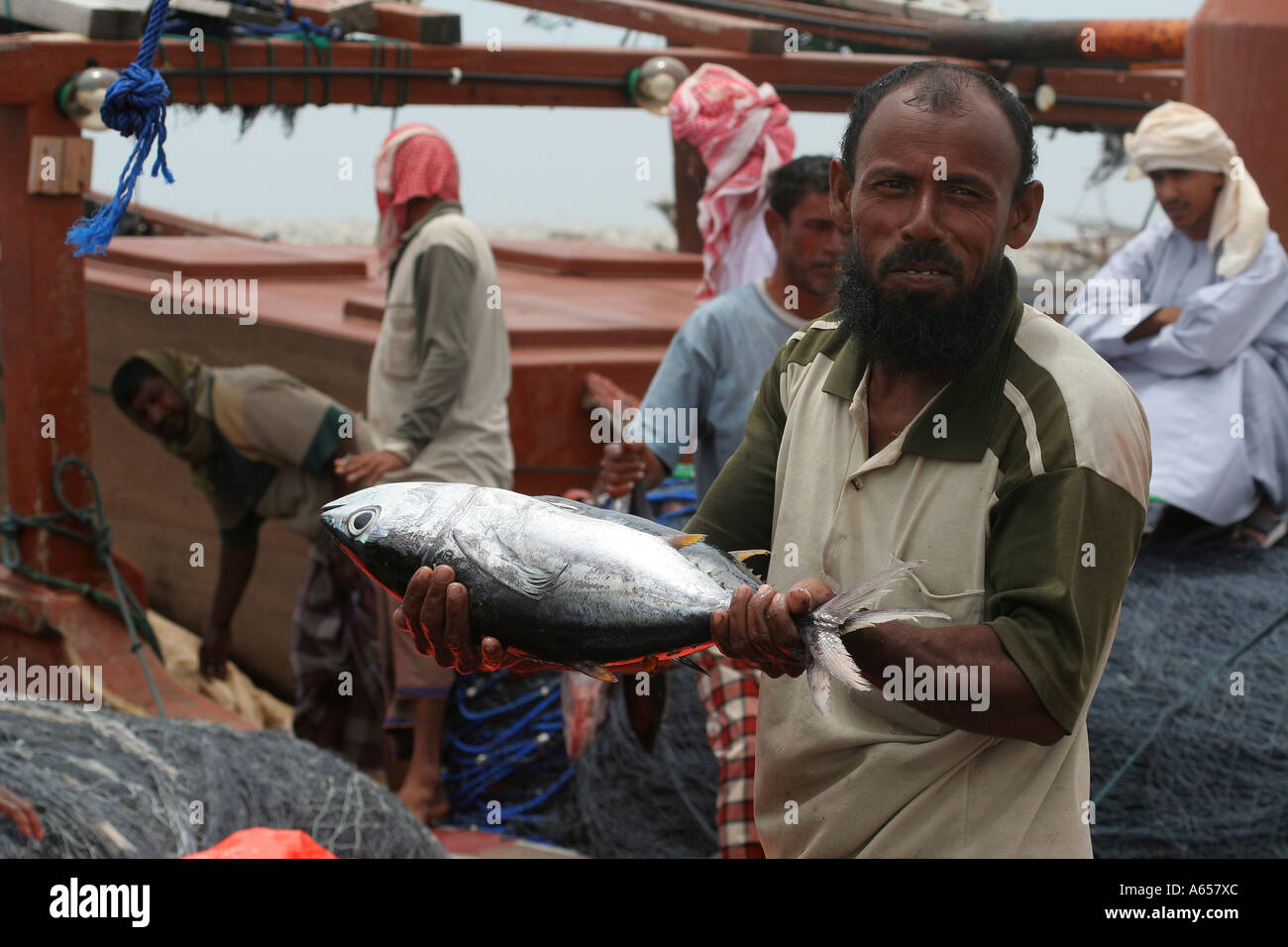 Indian workers onloading fish from a dhow in Sur , Oman Stock Photo - Alamy