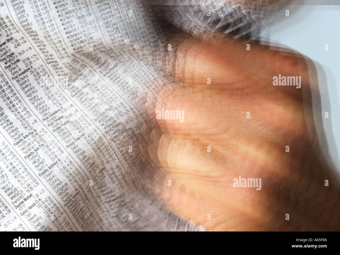 male hand grabbing newspaper financial section in anger abstract Stock Photo