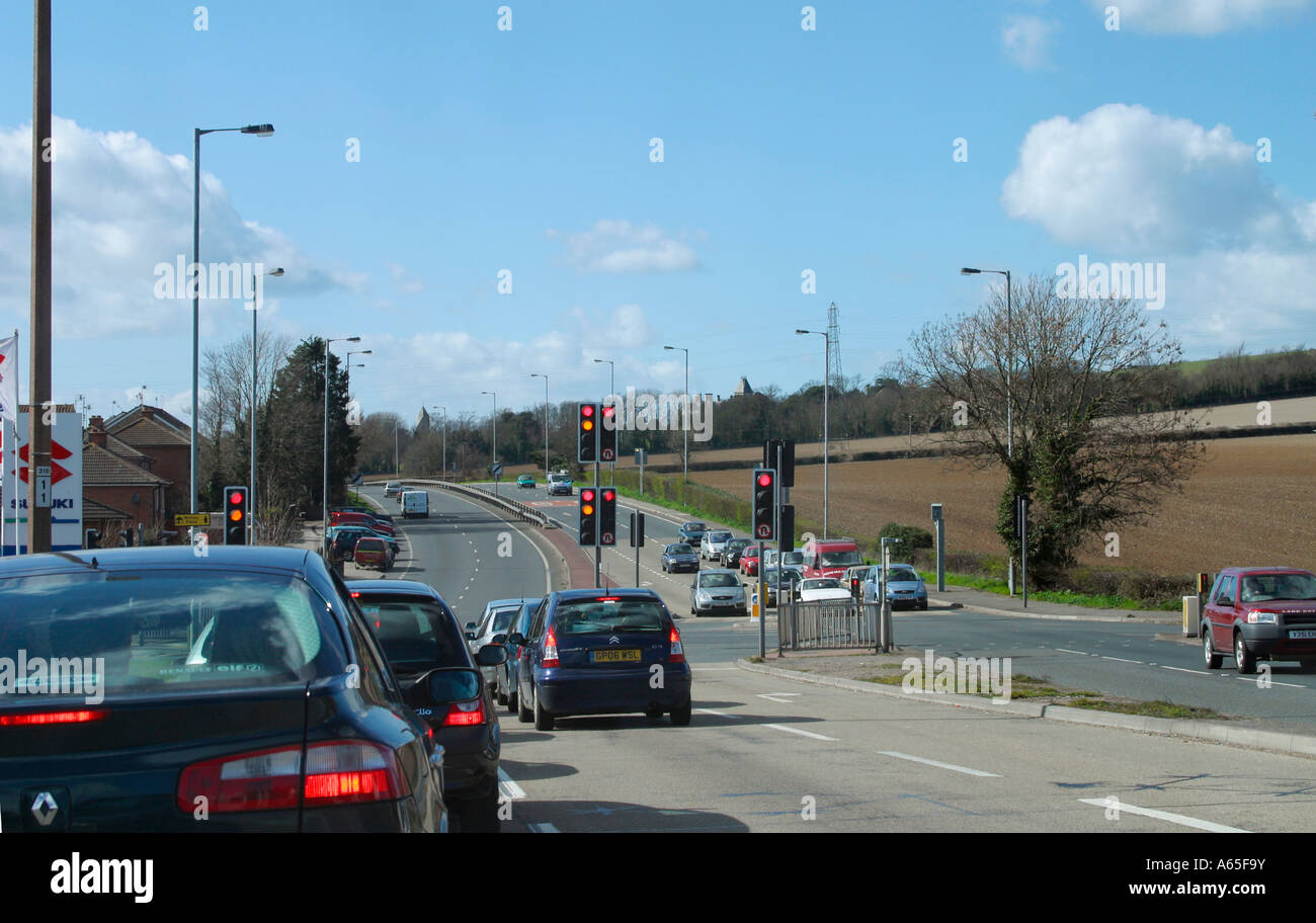 Traffic waiting at junction on UK trunk road with traffic lights about to turn green. Stock Photo
