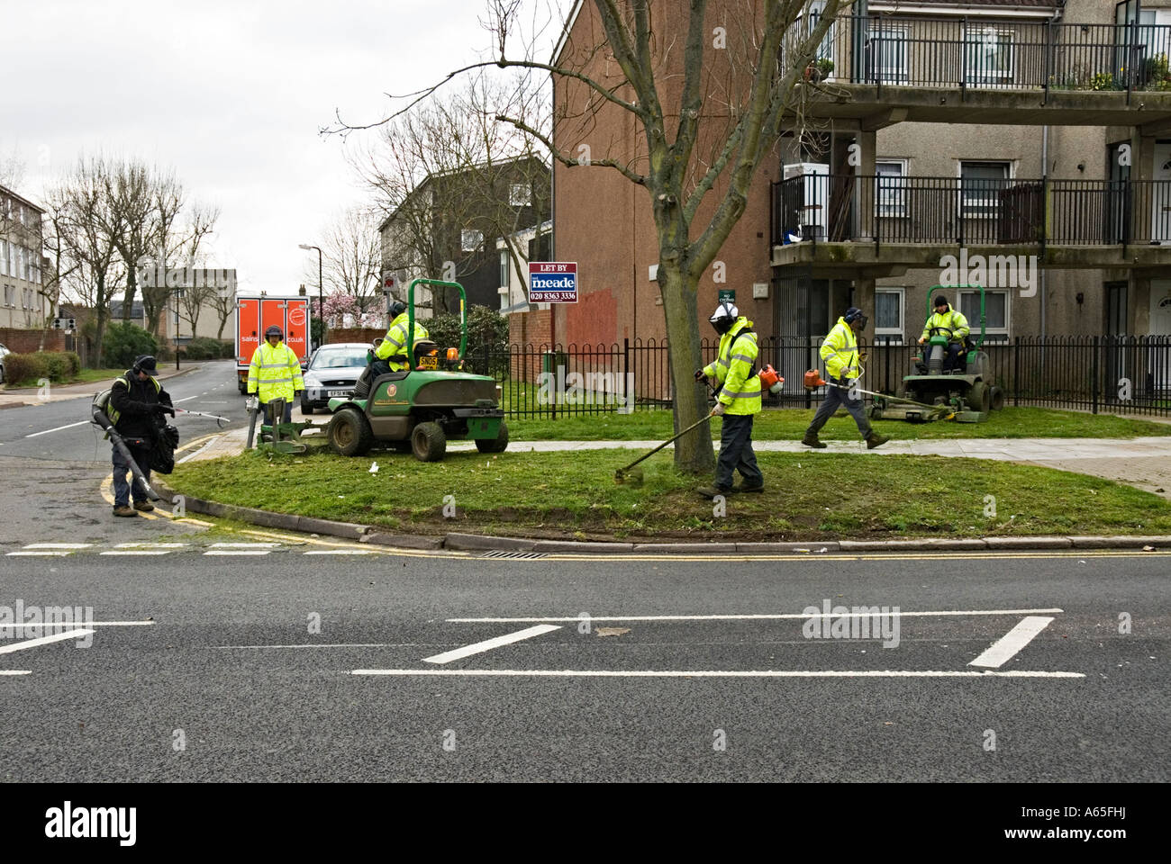Council workers trimming verges using mechanical trimmers Stock Photo
