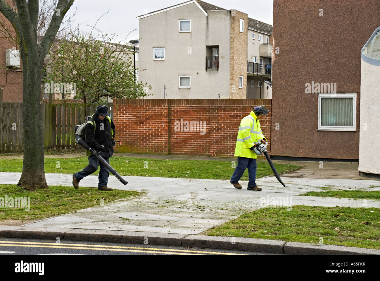 Council workers gathering cut grass using hand held mechanical blowers Stock Photo Alamy