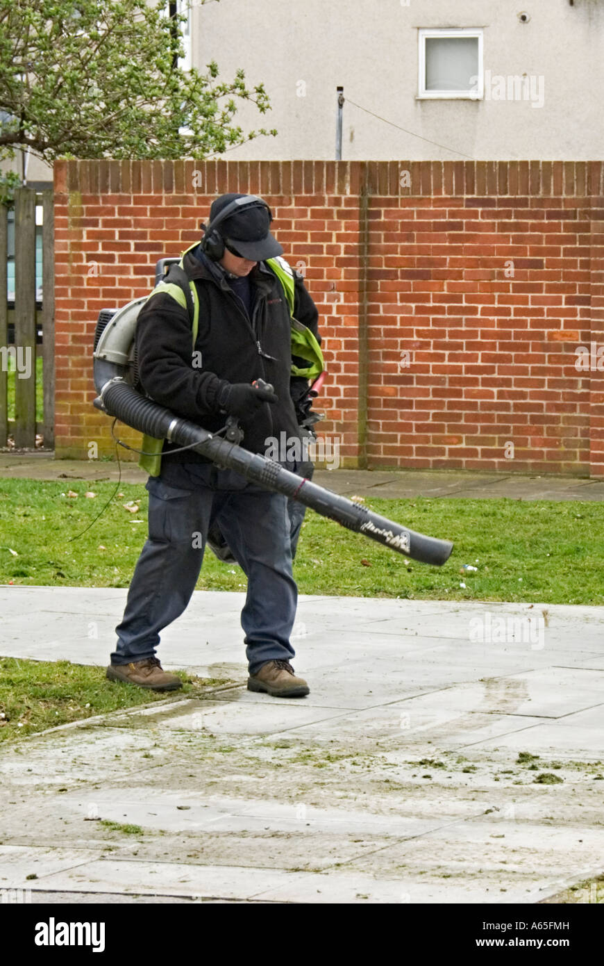 Council workers gathering cut grass using hand held mechanical blowers Stock Photo Alamy