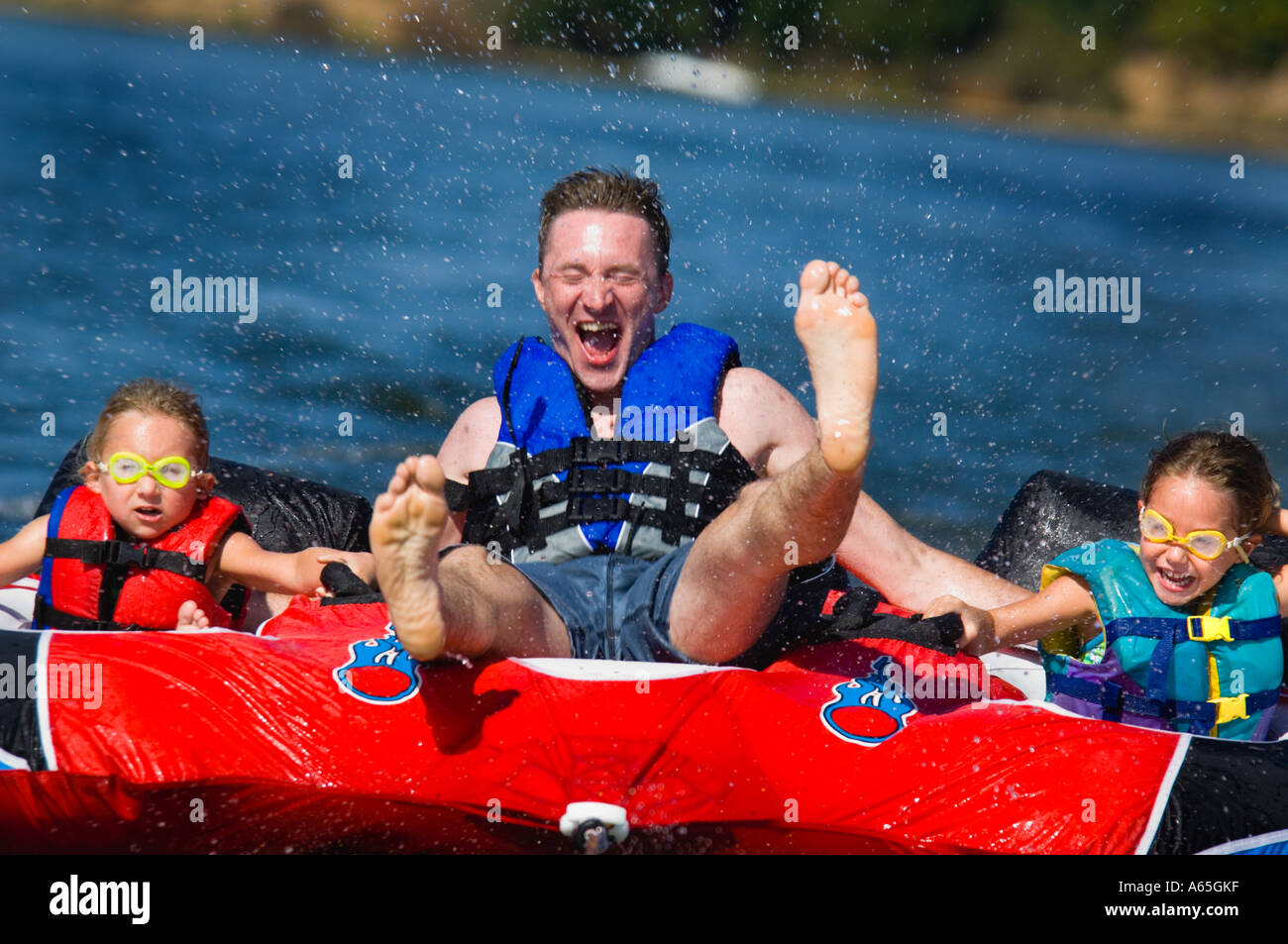 Dad with kids on inner tube Stock Photo Alamy