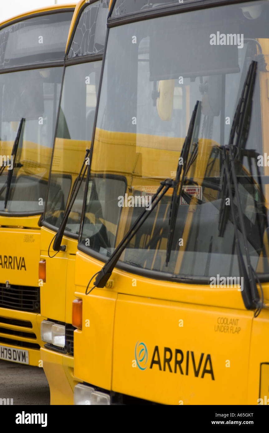 Arriva wales yellow painted school buses parked in depot Stock Photo