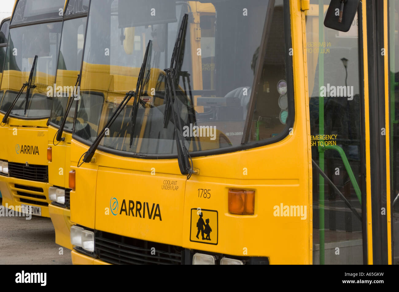 Arriva wales yellow painted school buses parked in depot Stock Photo