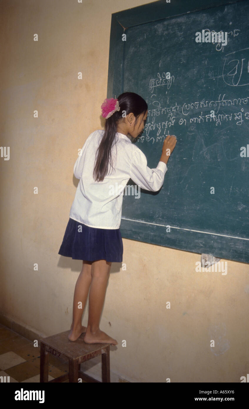 Cambodian school girl writing on blackboard Stock Photo