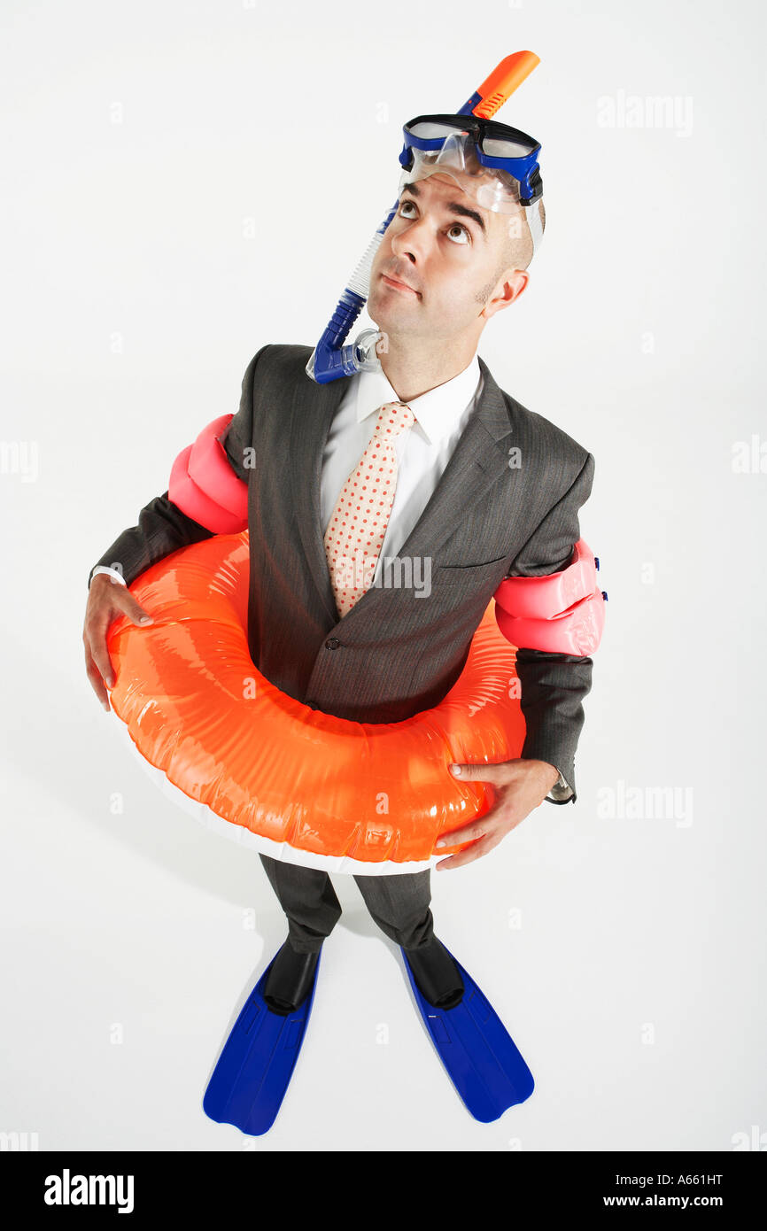 Middle-aged businessman in flippers, inflatable rubber ring, snorkel ...