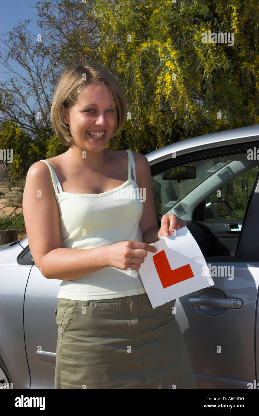 Young driver tearing up her L plates after passing her driving test. Stock Photo