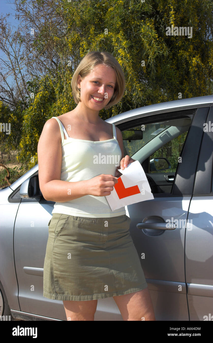Young driver tearing up her L plates after passing her driving test. Stock Photo