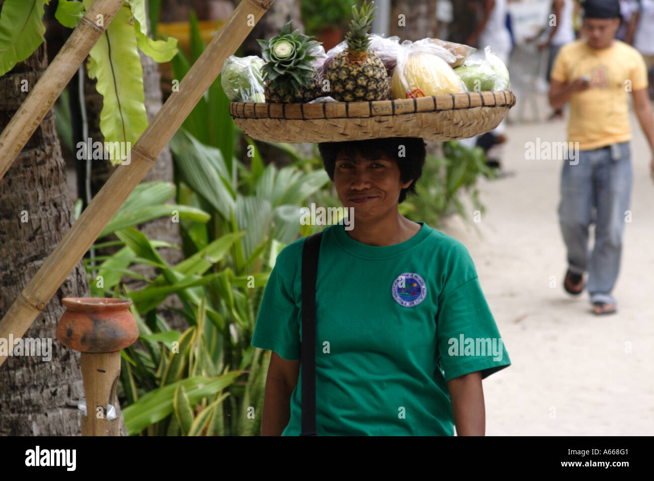 Boracay, Philippine Islands, woman walking with a basket of fruit